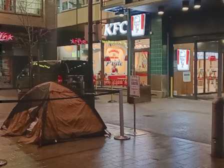 Itiksen kulma, jossa on nyt KFC. Ulkona on märkää, pimeää ja kylmää, ja ruskea yhden hengen teltta.